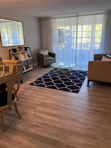 a bedroom with wooden floor and a window