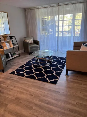 a bedroom with wooden floor and a window