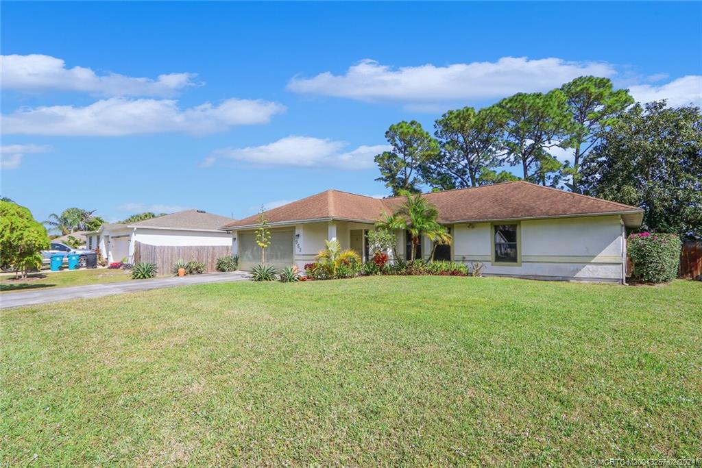 952 Southwest Commonwealth Road Port St. Lucie, FL 34953 - Photo 1 of 33 a front view of a house with a yard and garage