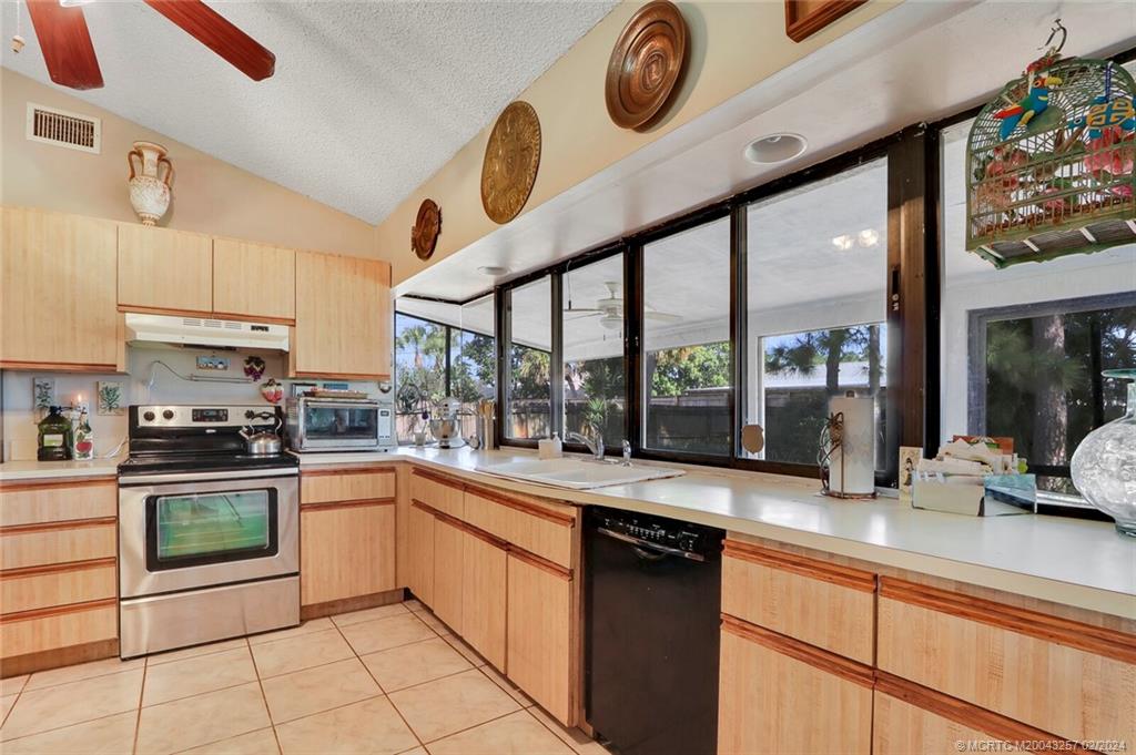 952 Southwest Commonwealth Road Port St. Lucie, FL 34953 - Photo 11 of 33 a kitchen with a stove a sink and cabinets
