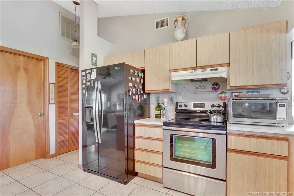952 Southwest Commonwealth Road Port St. Lucie, FL 34953 - Photo 12 of 33 a kitchen with stainless steel appliances granite countertop a refrigerator a stove and a sink
