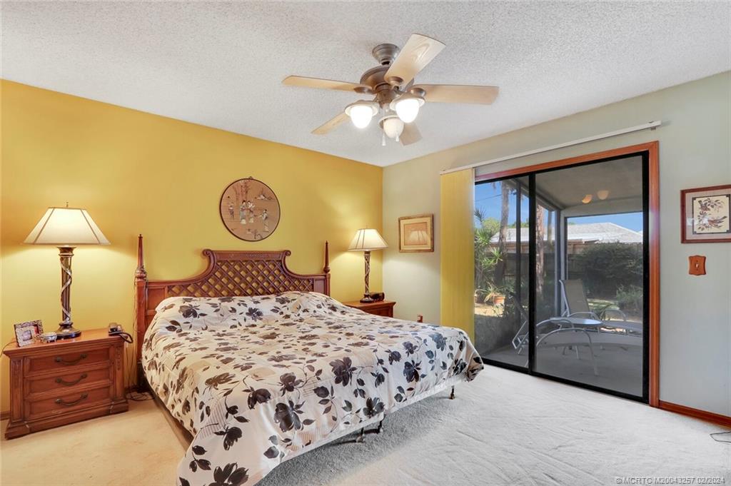 952 Southwest Commonwealth Road Port St. Lucie, FL 34953 - Photo 15 of 33 a bedroom with a bed and a chandelier