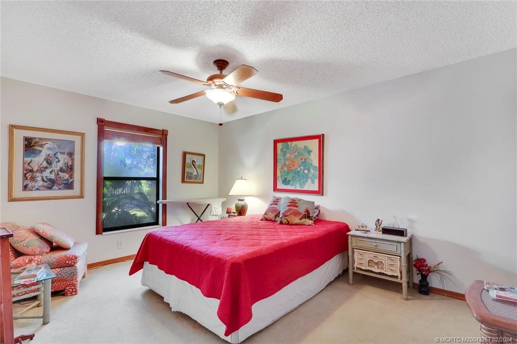 952 Southwest Commonwealth Road Port St. Lucie, FL 34953 - Photo 20 of 33 a bedroom with a bed and a chandelier