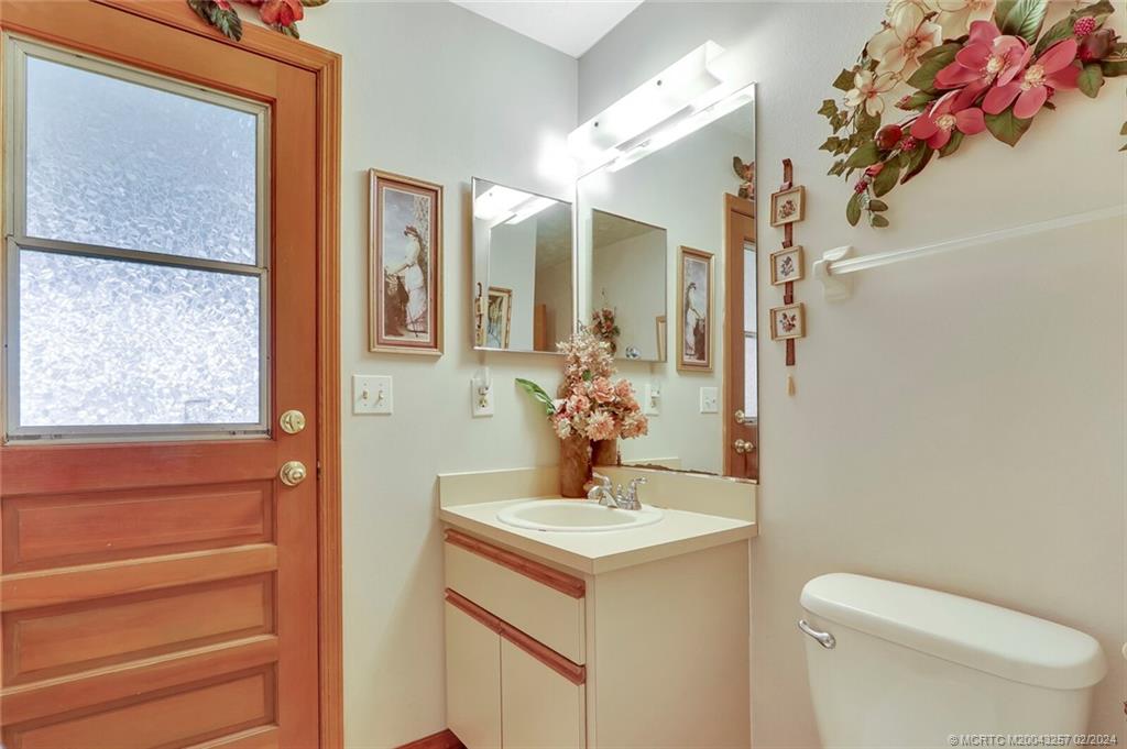 952 Southwest Commonwealth Road Port St. Lucie, FL 34953 - Photo 21 of 33 a bathroom with a toilet sink and mirror