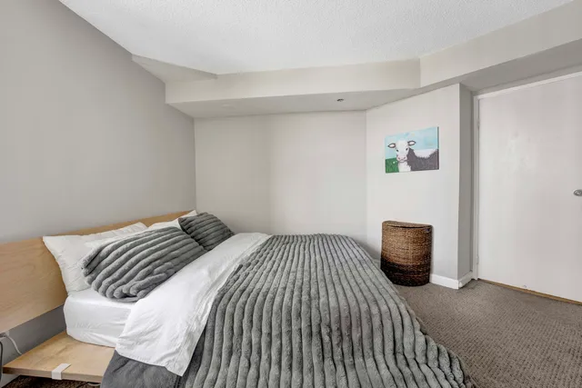 a bedroom with a bed and a painting on the wall