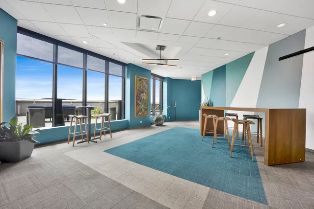 a living room with furniture a ceiling fan and a large window