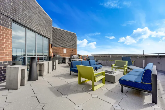 a roof deck with table and chairs couches with wooden floor and fence