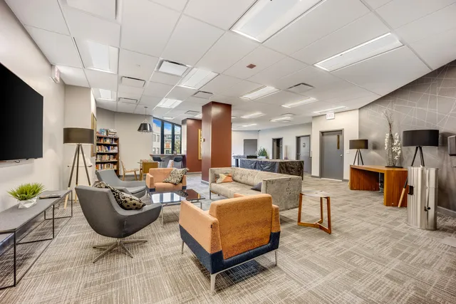a living room with furniture a flat screen tv and kitchen view