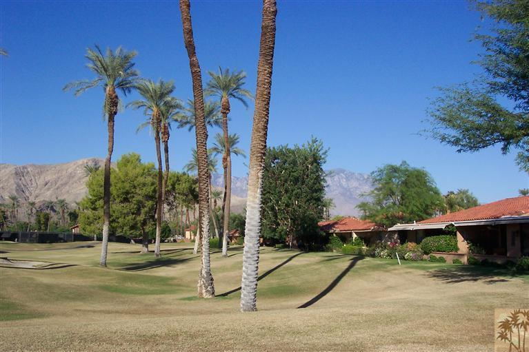 66 La Ronda Drive Rancho Mirage, CA 92270 - Photo 3 of 8 a backyard of a house with table and chairs under an umbrella