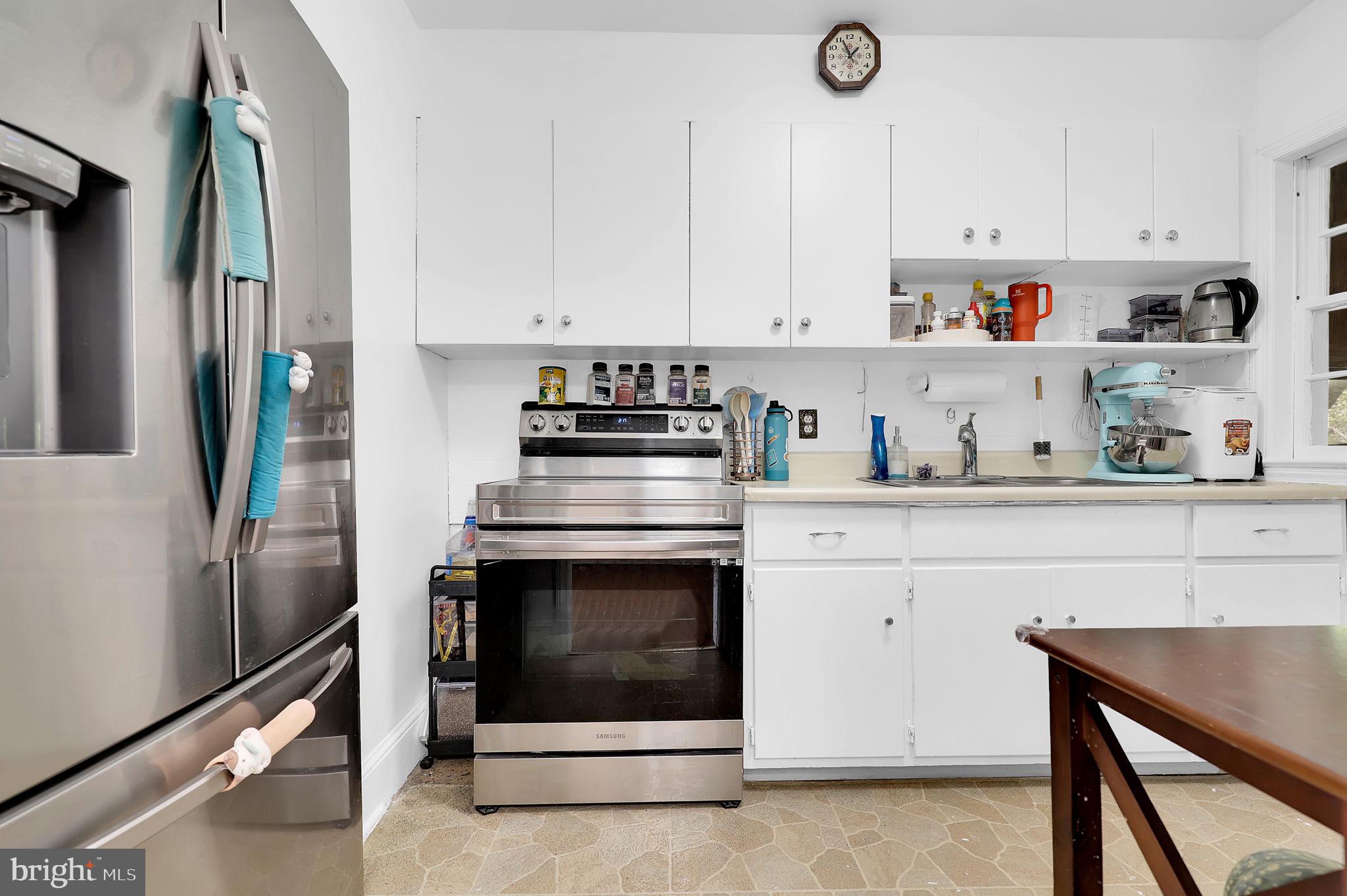 404 Biggs Avenue Frederick, MD 21702 - Photo 7 of 47 a kitchen with stainless steel appliances granite countertop a refrigerator a stove and white cabinets with wooden floor