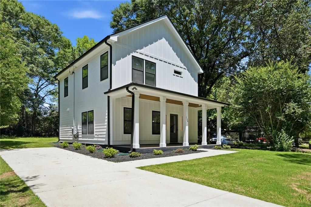 134 Henry Meyer Road Winterville, GA 30683 - Photo 2 of 34 a view of a white house with a large windows and a yard with plants and large trees