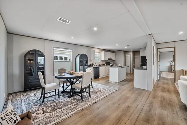 a living room with furniture a dining table and chairs with wooden floor