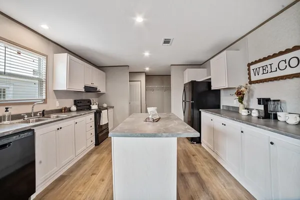 a kitchen with a sink stove cabinets and refrigerator