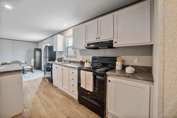 a kitchen with granite countertop white cabinets and white appliances
