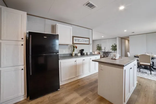a kitchen with white cabinets and refrigerator