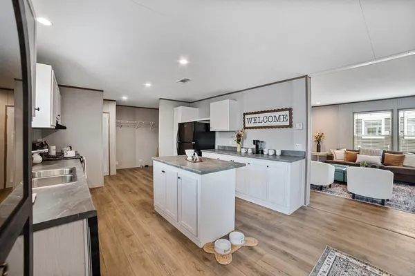 a large living room with stainless steel appliances kitchen island furniture a refrigerator and a stove top oven