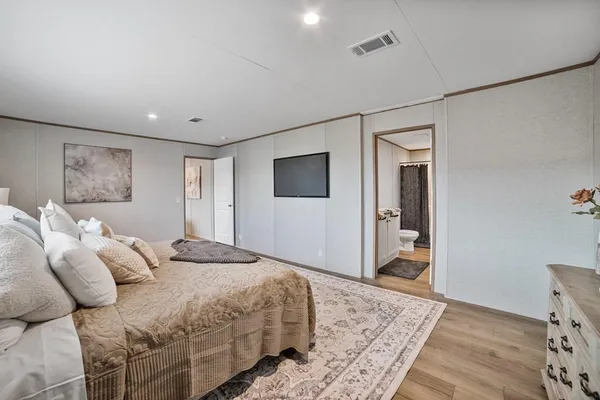 a bedroom with a bed and a flat screen tv