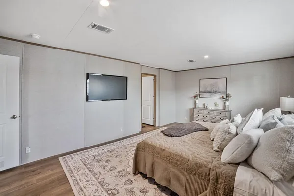 a bedroom with a bed and wooden floor