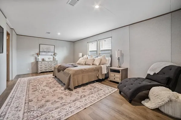 a bedroom with a bed and wooden floor