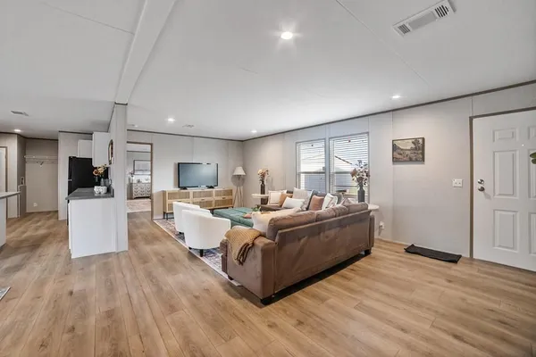 a living room with furniture and a wooden floor