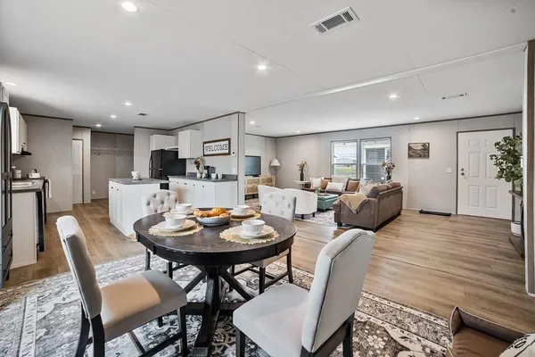 a living room with furniture a dining table and kitchen view