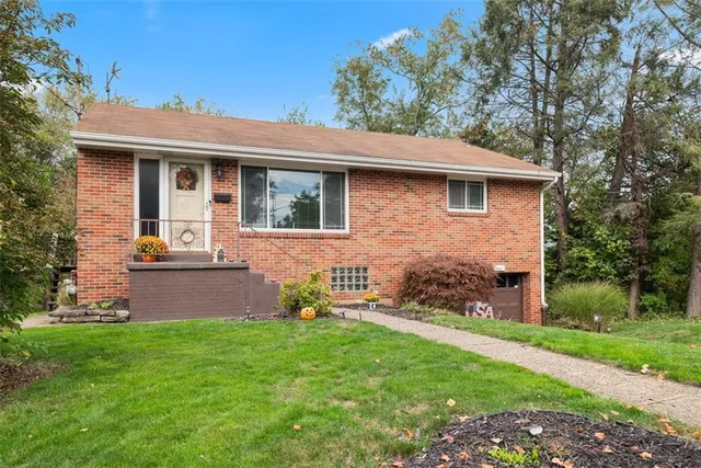 a front view of a house with a garden and yard
