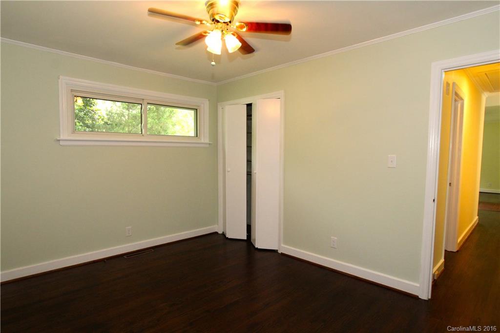 825 Manhasset Road Charlotte, NC 28209 - Photo 13 of 20 an empty room with a window and a ceiling fan