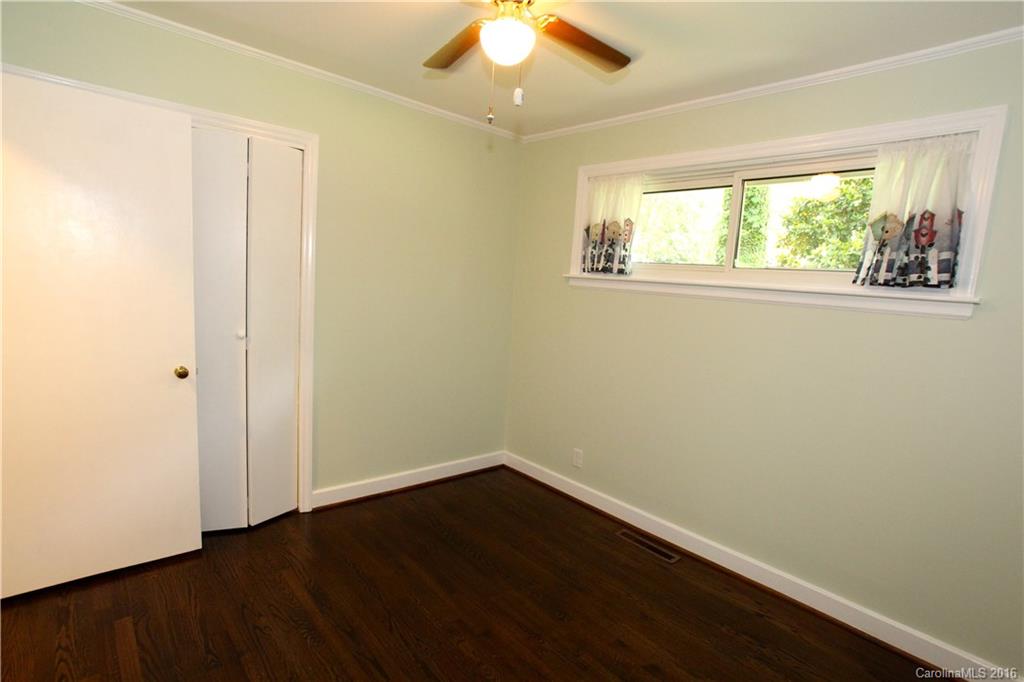 825 Manhasset Road Charlotte, NC 28209 - Photo 14 of 20 a view of an empty room with wooden floor and a window