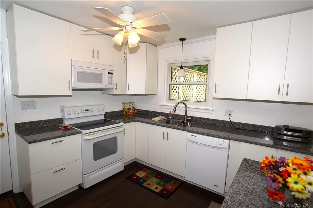 825 Manhasset Road Charlotte, NC 28209 - Photo 7 of 20 a kitchen with stainless steel appliances granite countertop a sink a stove a microwave a counter space and cabinets