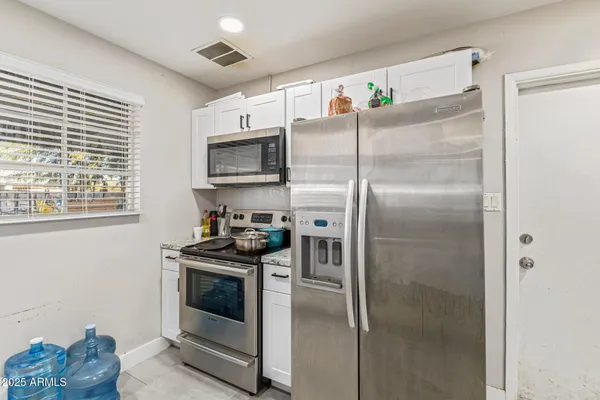 a kitchen with a refrigerator a stove and a window