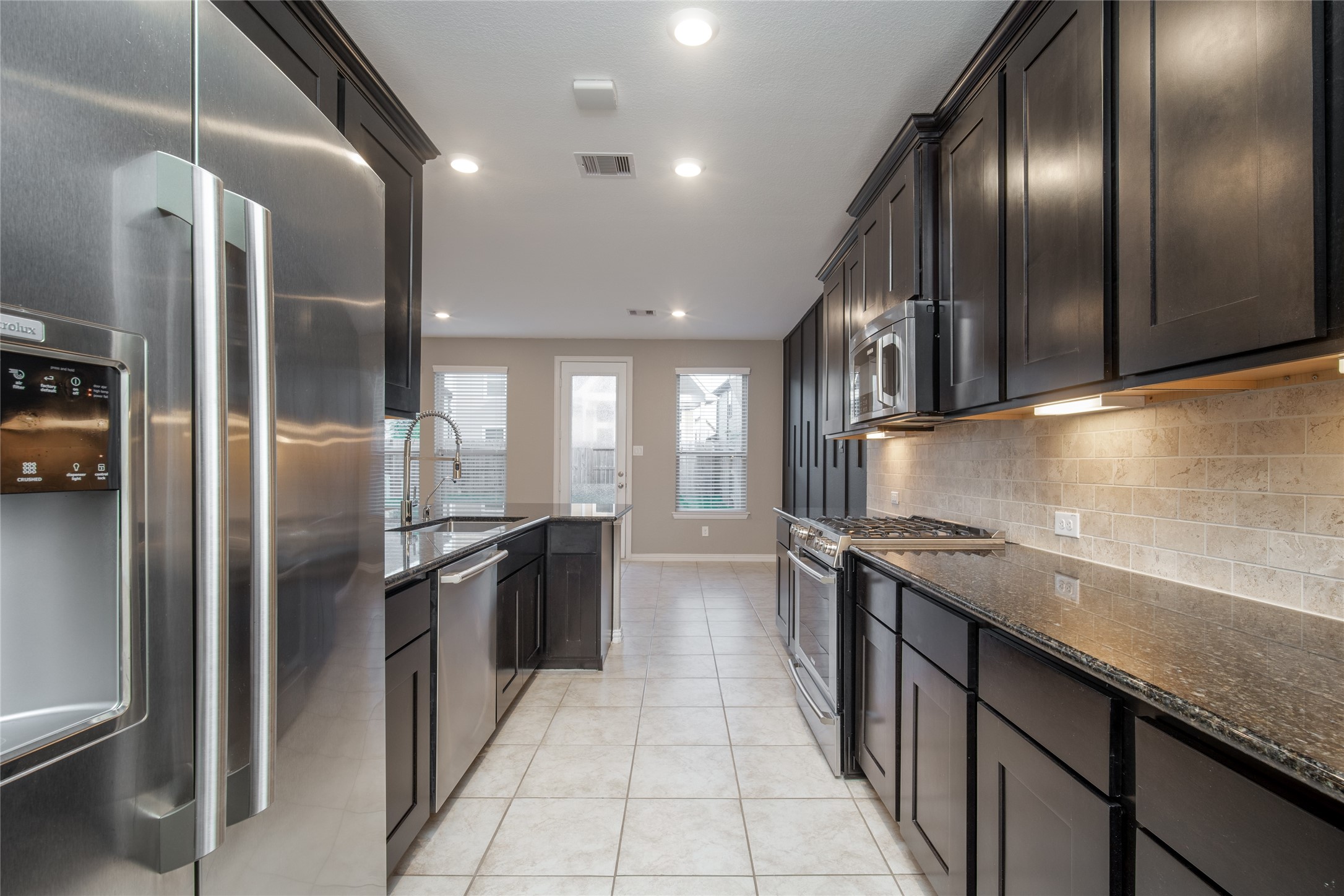 1826 Ryon Falls Drive Richmond, TX 77469 - Photo 17 of 35 a kitchen with stainless steel appliances granite countertop a refrigerator and a sink