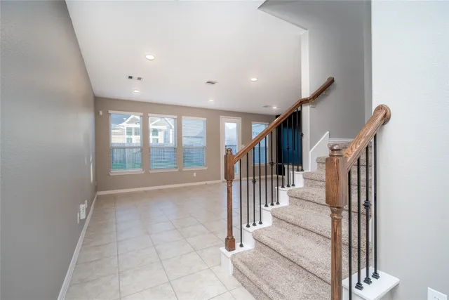 a view of a hallway with wooden floor and staircase