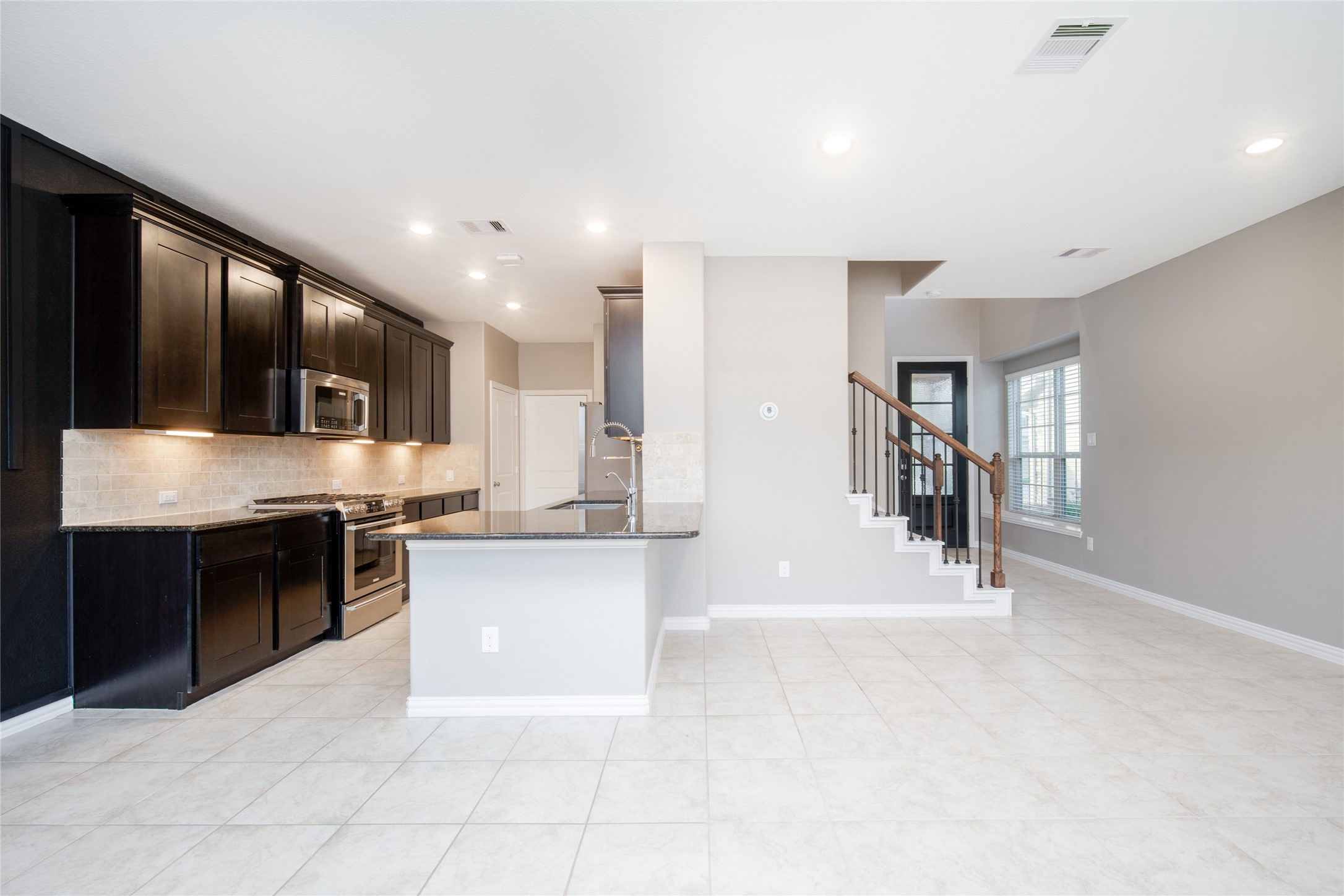 1826 Ryon Falls Drive Richmond, TX 77469 - Photo 9 of 35 a large white kitchen with stainless steel appliances granite countertop a stove and a sink