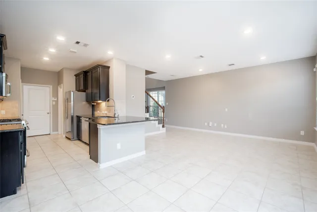 a large white kitchen with a sink and cabinets