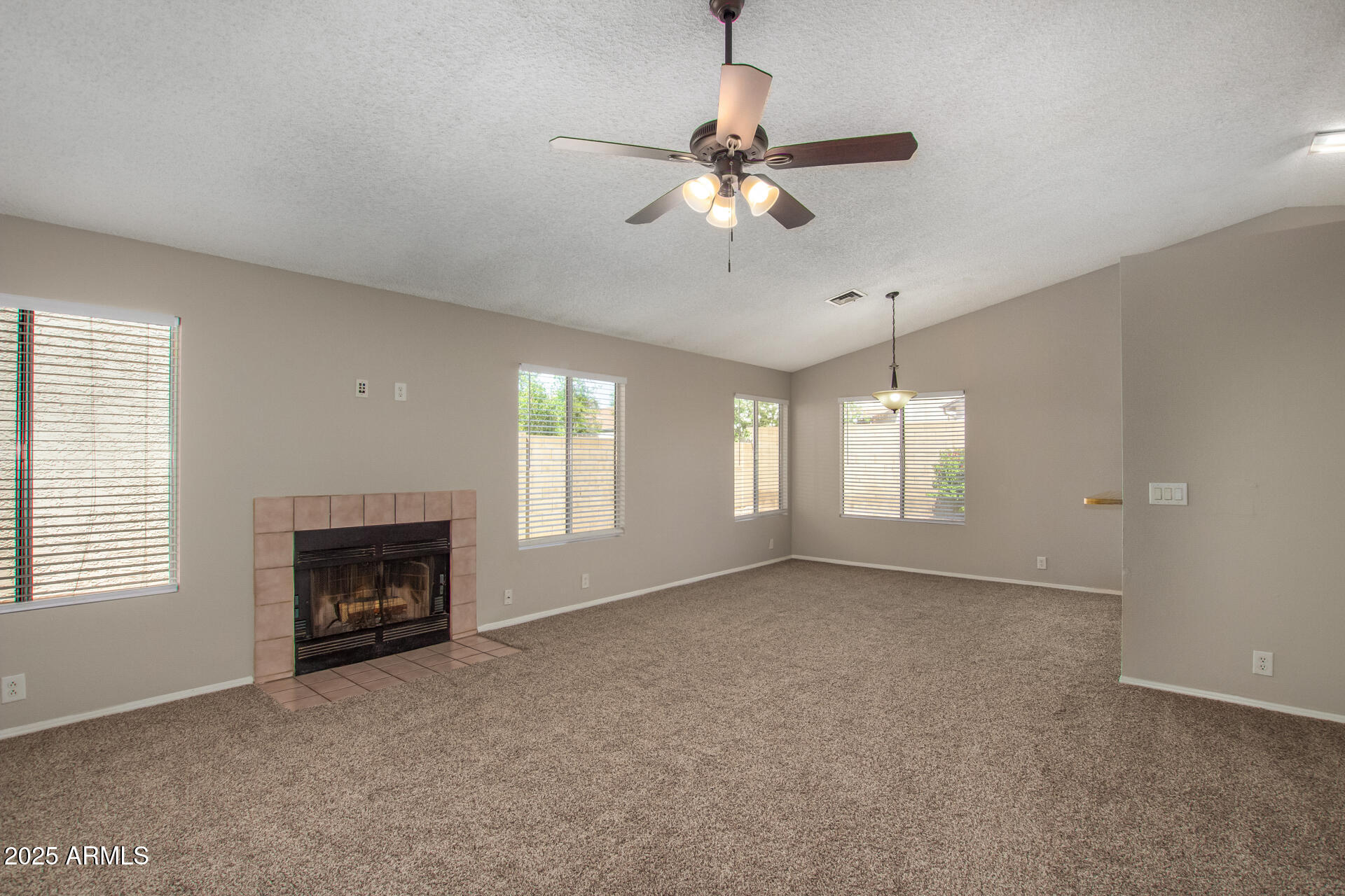 10015 North 66th Drive Glendale, AZ 85302 - Photo 3 of 20 a view of empty room with fireplace and window