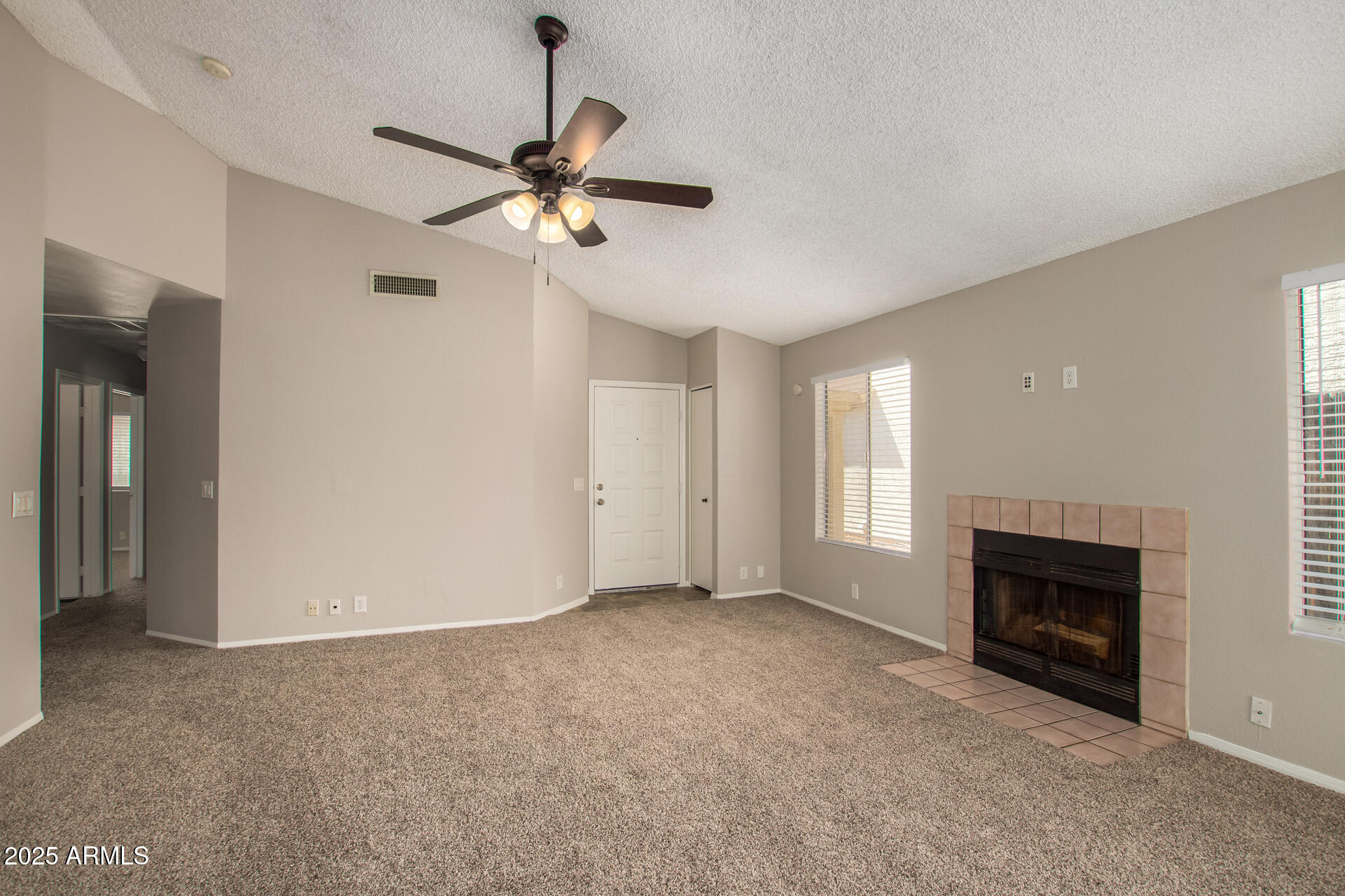 10015 North 66th Drive Glendale, AZ 85302 - Photo 5 of 20 a view of empty room with fireplace and fan