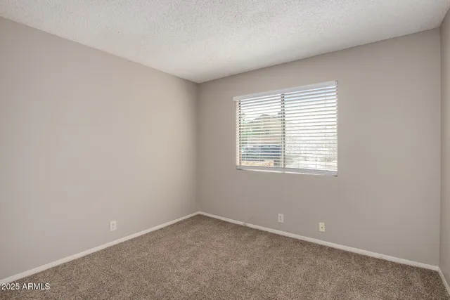 an empty room with chandelier fan