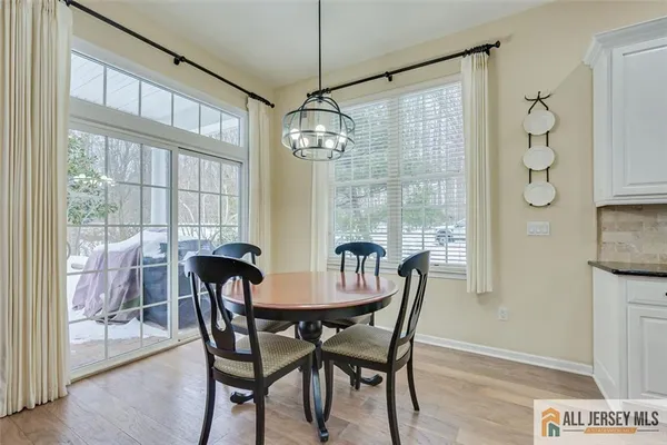 a view of a dining room with furniture large windows and wooden floor