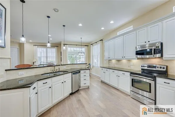 a large kitchen with stainless steel appliances granite countertop a stove a sink and a granite counter tops