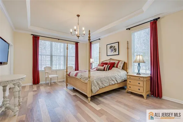 a bedroom with a large bed and a chandelier