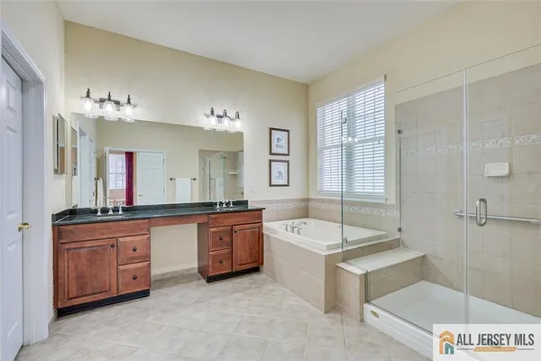 a large bathroom with a tub sink and mirror
