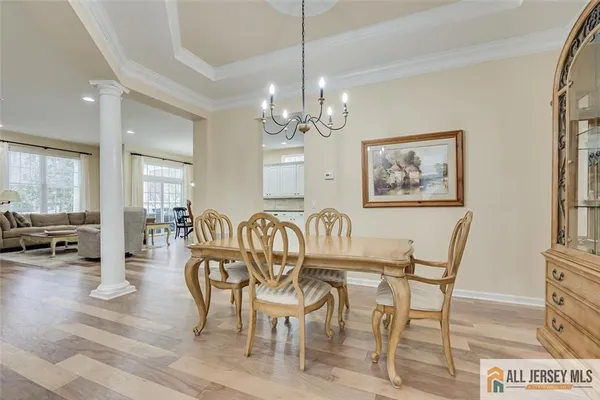 a view of a dining room with furniture a chandelier and wooden floor