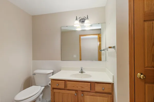 a bathroom with a sink vanity mirror and toilet