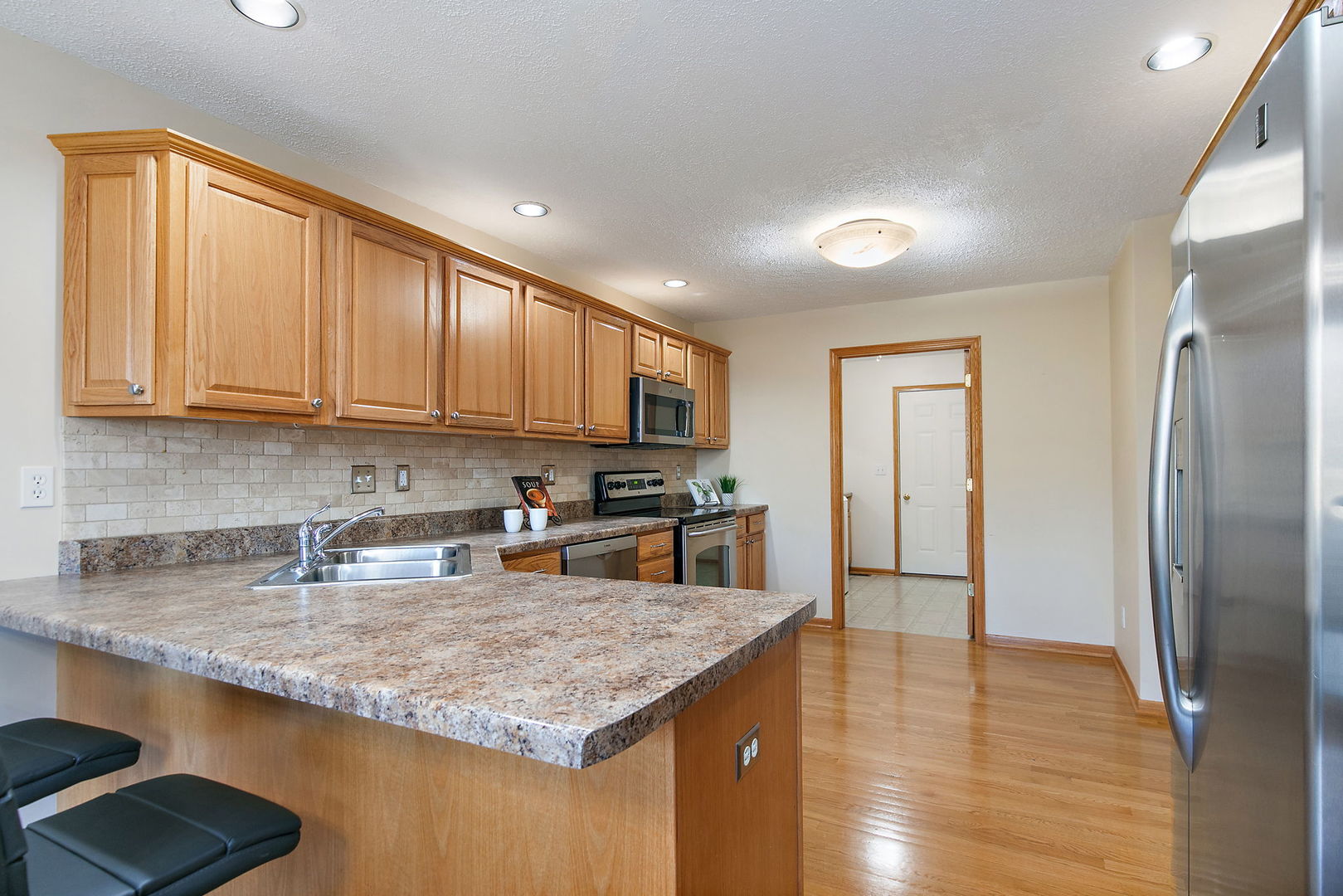 543 Brant Circle DeKalb, IL 60115 - Photo 9 of 28 a kitchen with stainless steel appliances granite countertop a refrigerator sink and cabinets