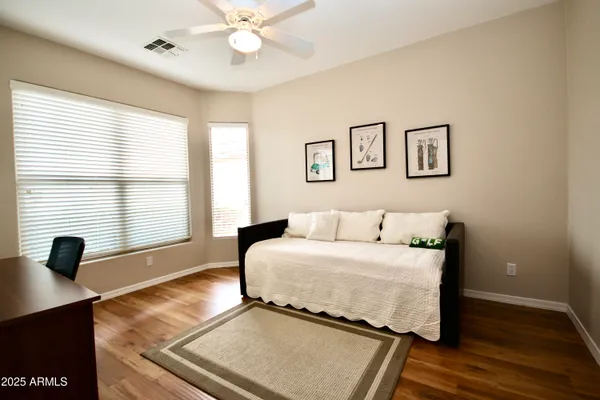 a bedroom with a bed and wooden floor