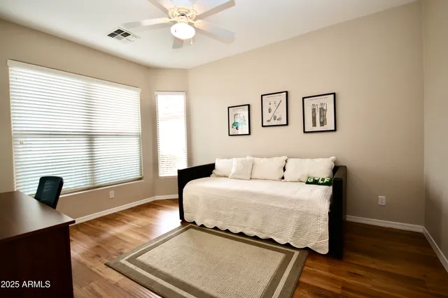 a bedroom with a bed and wooden floor