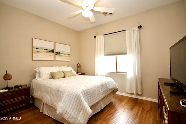 a bedroom with a bed and a flat tv screen on a dresser