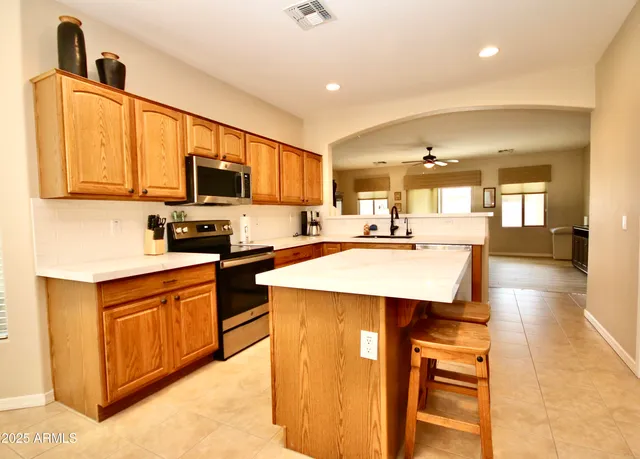 a kitchen with stainless steel appliances kitchen island granite countertop a sink and cabinets