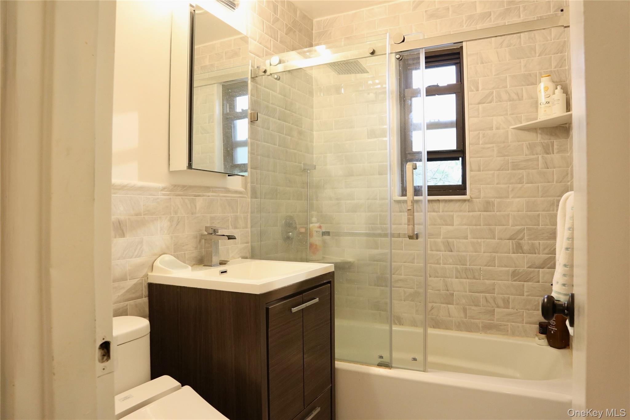 10 Terrace Circle, Unit 3B Great Neck, NY 11021 - Photo 8 of 8 a bathroom with a sink a toilet and shower