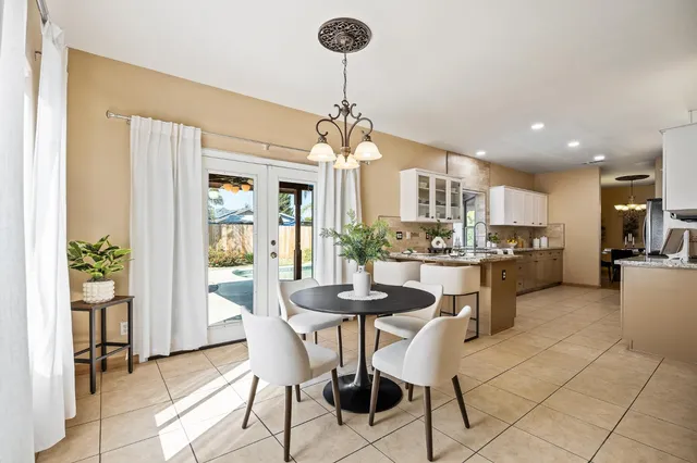 a view of a dining room with furniture and a chandelier